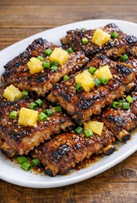 Plat de travers de porc caramélisés à l'ananas et à l'ail, décorés de ciboulette